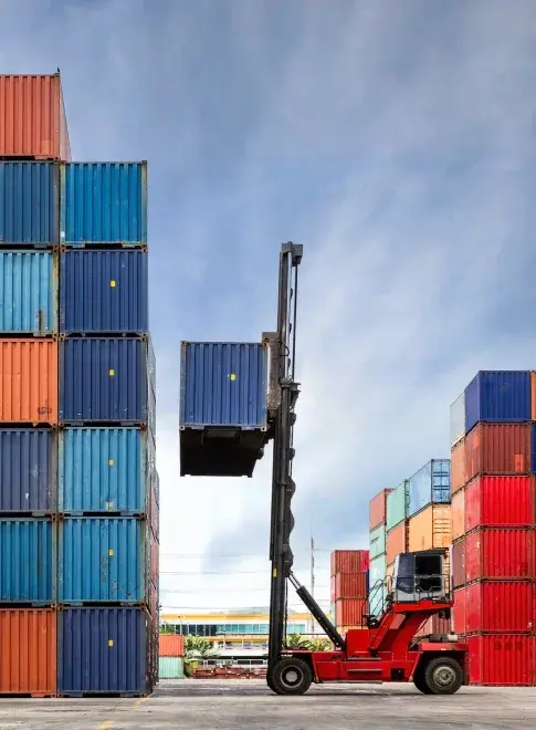 Nationwide Supply & Fast Shipping Logistics A reach stacker moving a shipping container amidst stacks of containers, symbolizing nationwide supply and fast shipping.