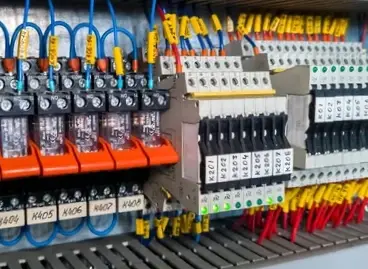 A close-up of a neatly wired electrical control panel with relays and labeled terminals, representing a product from United Industries VA.